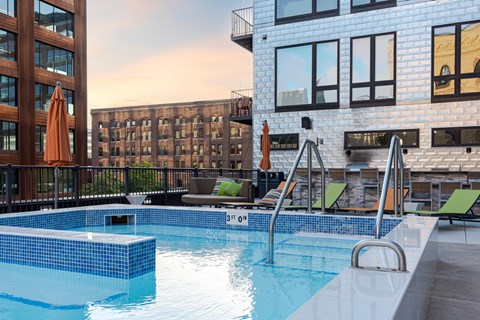 A swimming pool with a blue tiled edge and a metal ladder.