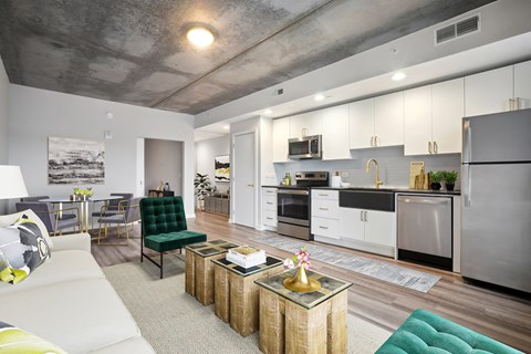 A modern kitchen with a green chair and a white couch.