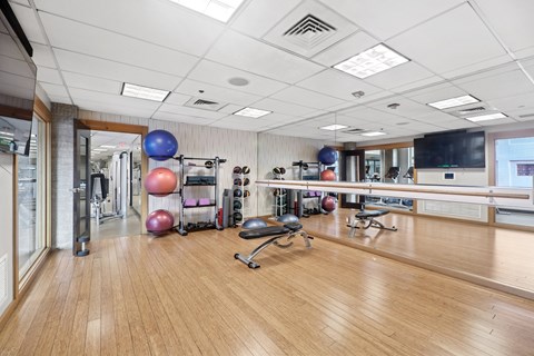 A gym with a variety of equipment including a bench, weights, and a mirror.