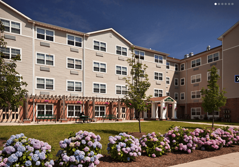A building with a flower bed in front of it.