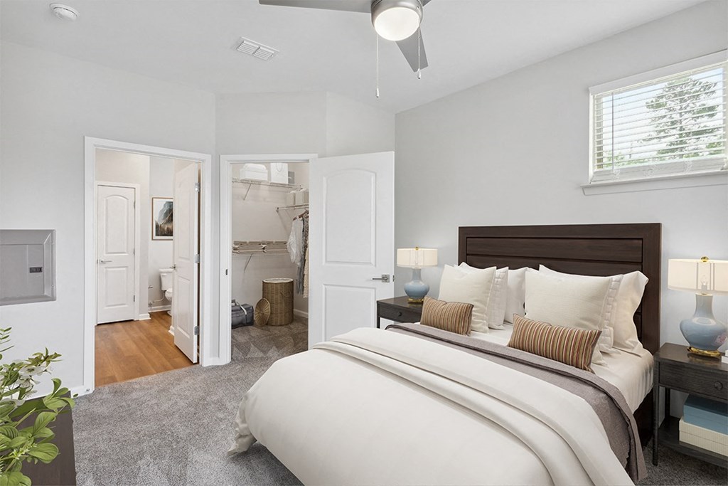 a bedroom with a large bed and a bathroom in the background at Two Addison Place Apartments , Georgia, 31322