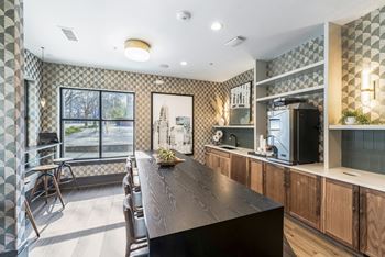 a kitchen with a long wooden table and a large window  at Park and Kingston, Charlotte, NC