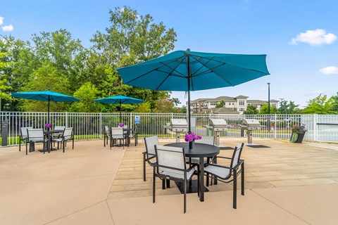a patio with tables and chairs and umbrellas at Sycamore at Tyvola, Charlotte, NC