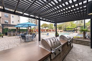 a patio with a grill and tables with umbrellas at Park and Kingston, Charlotte, NC, 28203