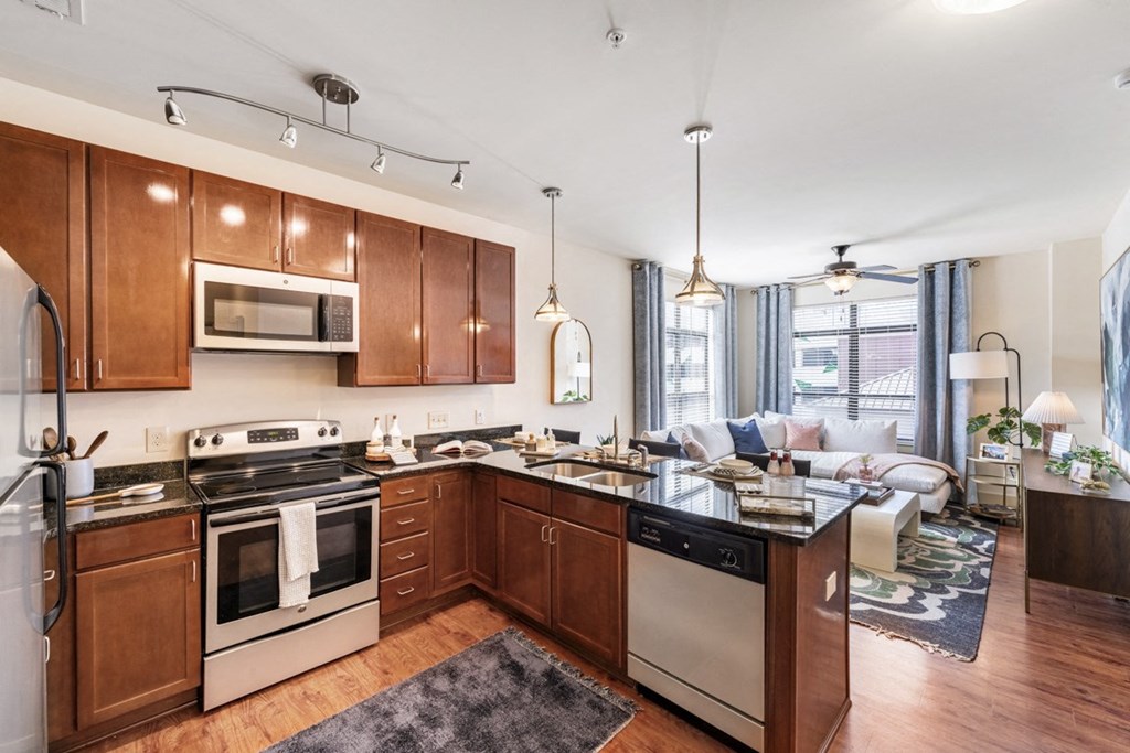 a kitchen with wooden cabinets and a living room with a couch  at Park and Kingston, Charlotte