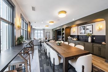 a dining room with a long wooden table and white chairs at Park & Kingston, Charlotte, NC 28203