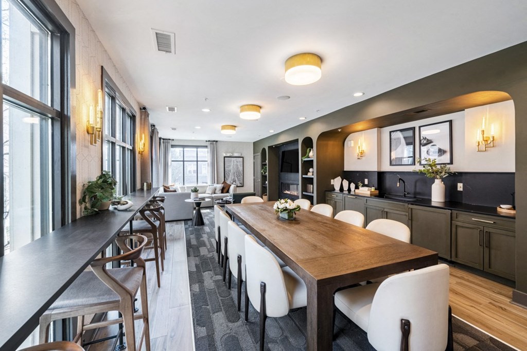 a dining room with a long wooden table and white chairs at Park & Kingston, Charlotte NC 28203