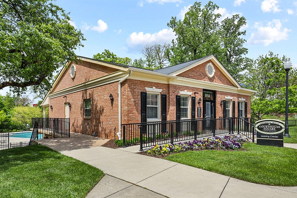 a brick building with a pool in the background  at Courthouse Square Apartments, Towson