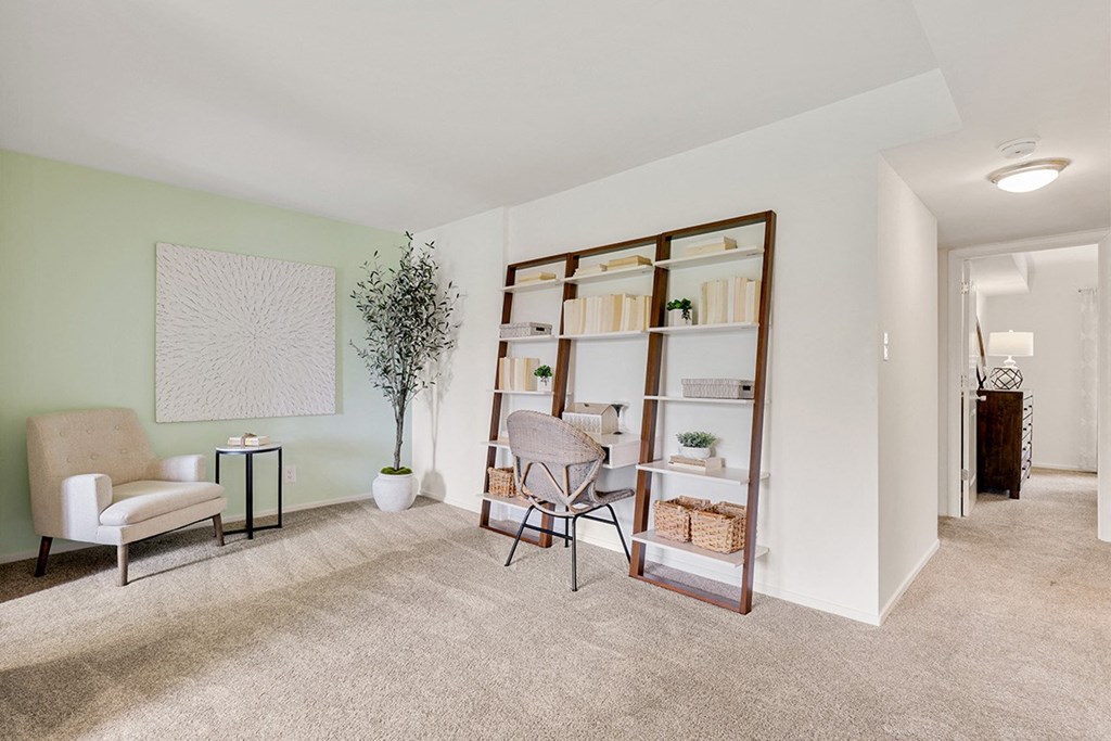 a living room with a bookshelf and a chair  at Courthouse Square Apartments, Maryland