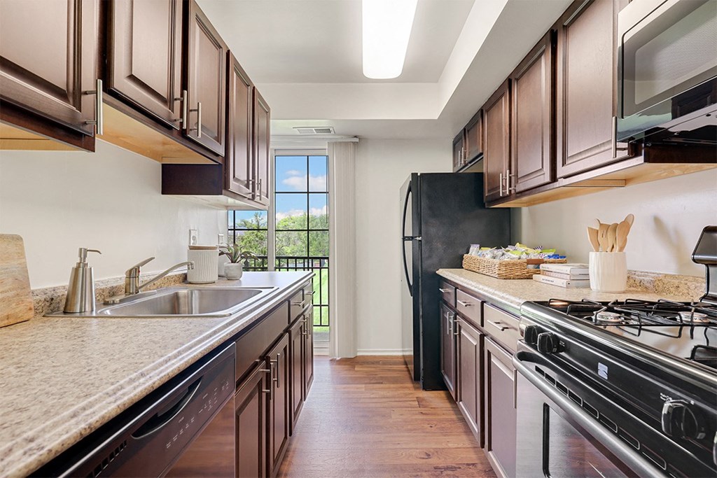 a kitchen with wooden cabinets and stainless steel appliances  at Courthouse Square Apartments, Maryland