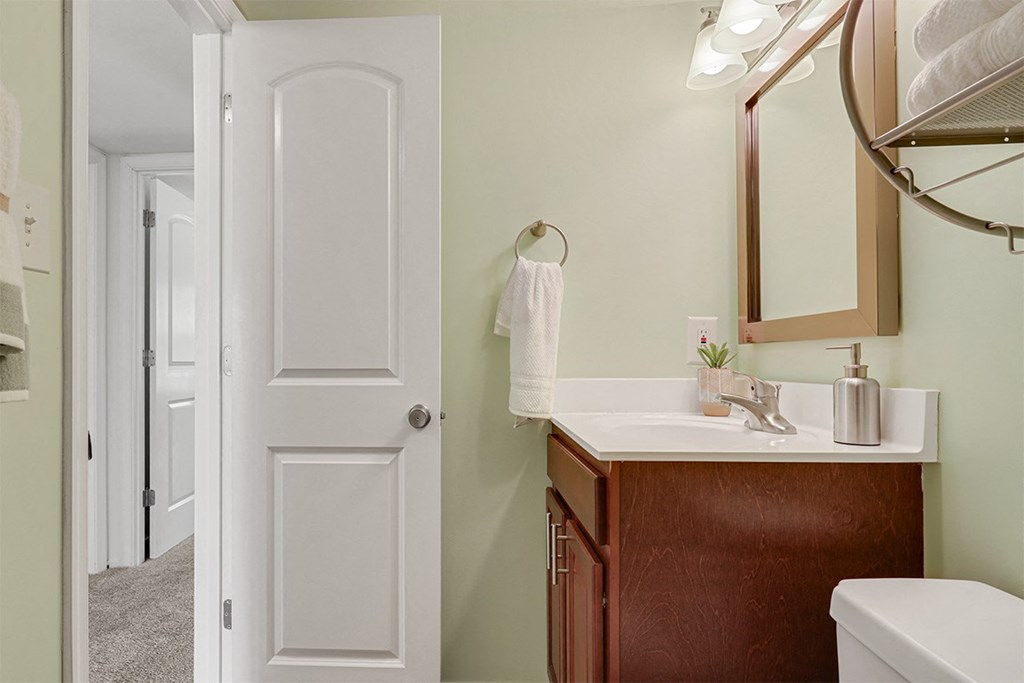 a bathroom with green walls and a white sink  at Courthouse Square Apartments, Towson, Maryland