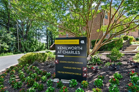A sign for Kenilworth at Charles is displayed in front of a landscaped area.