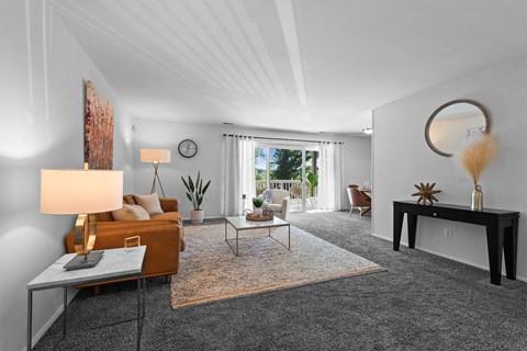 A living room with a grey carpet and a brown sofa.
