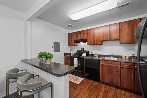 A kitchen with a black stove top oven and wooden cabinets.