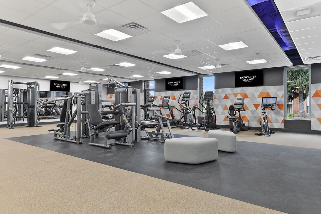 a gym with weights and other exercise equipment on the floor a gym with weights and other exercise equipment on the floor at Doncaster Village Apartments, Parkville, MD