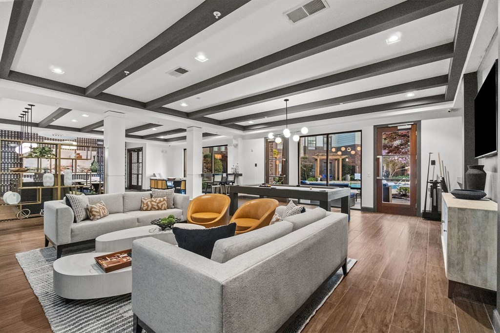 A modern clubroom with a grey sofa and a coffee table. at 1010 Dilworth Apartments, Charlotte, North Carolina