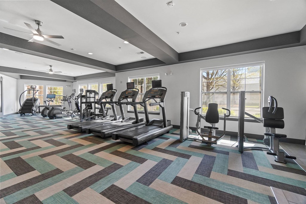 A gym with a variety of equipment including treadmills, weights, and a bench press at 1010 Dilworth Apartments, Charlotte, NC