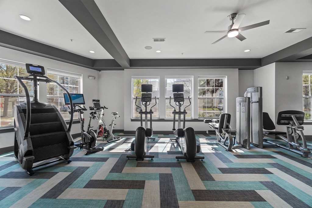 A gym with a variety of equipment including treadmills, stationary bikes, and weight machines at 1010 Dilworth Apartments, Charlotte