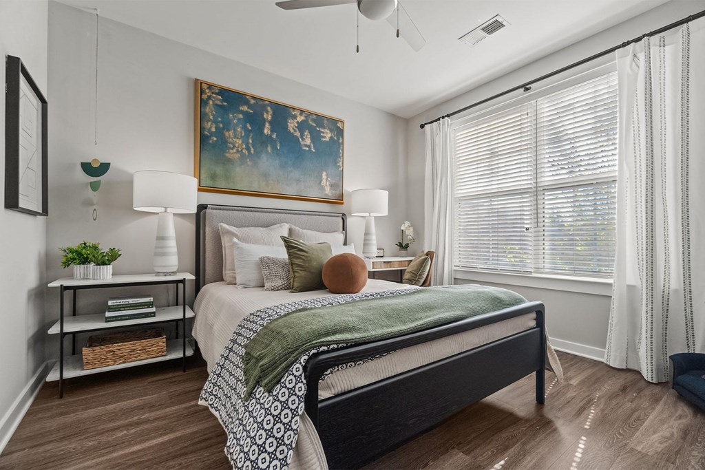 A bedroom with a large bed and a painting on the wall. at 1010 Dilworth Apartments, Charlotte 28204