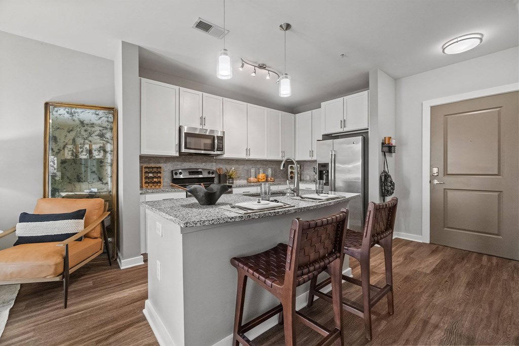 A kitchen with a counter and chairs. at 1010 Dilworth Apartments, Charlotte, NC