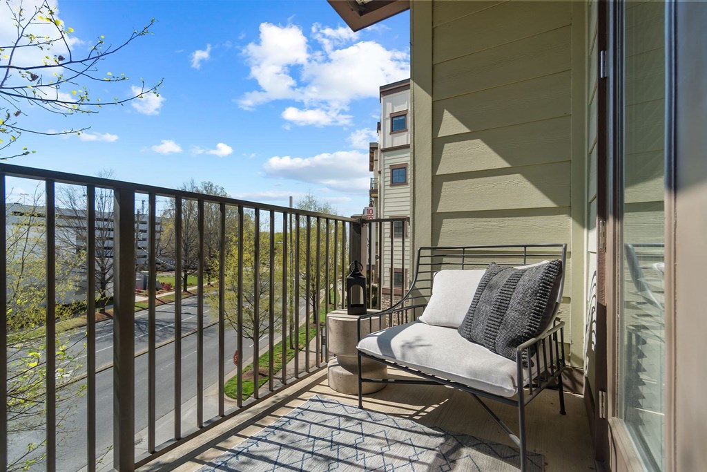 A balcony with a chair and a table. at 1010 Dilworth Apartments, North Carolina