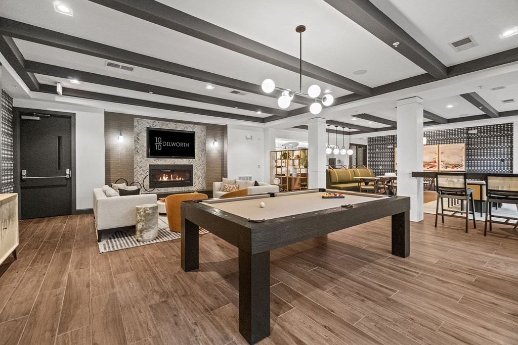 A billiard table is in the middle of a room with a fireplace at 1010 Dilworth Apartments, Charlotte, NC