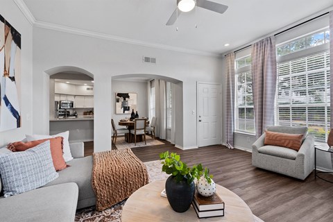 A living room with a grey couch, a brown throw pillow, and a wooden coffee table.