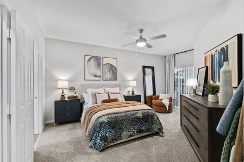 Master bedroom with ceiling fan and walk-in closet at Henley Tampa Palms Apartments, Tampa
