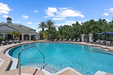 Resort style pool with sundeck and lounge chairs at Henley Tampa Palms Apartments, Florida