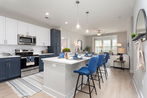 an open kitchen with a large island and blue chairs