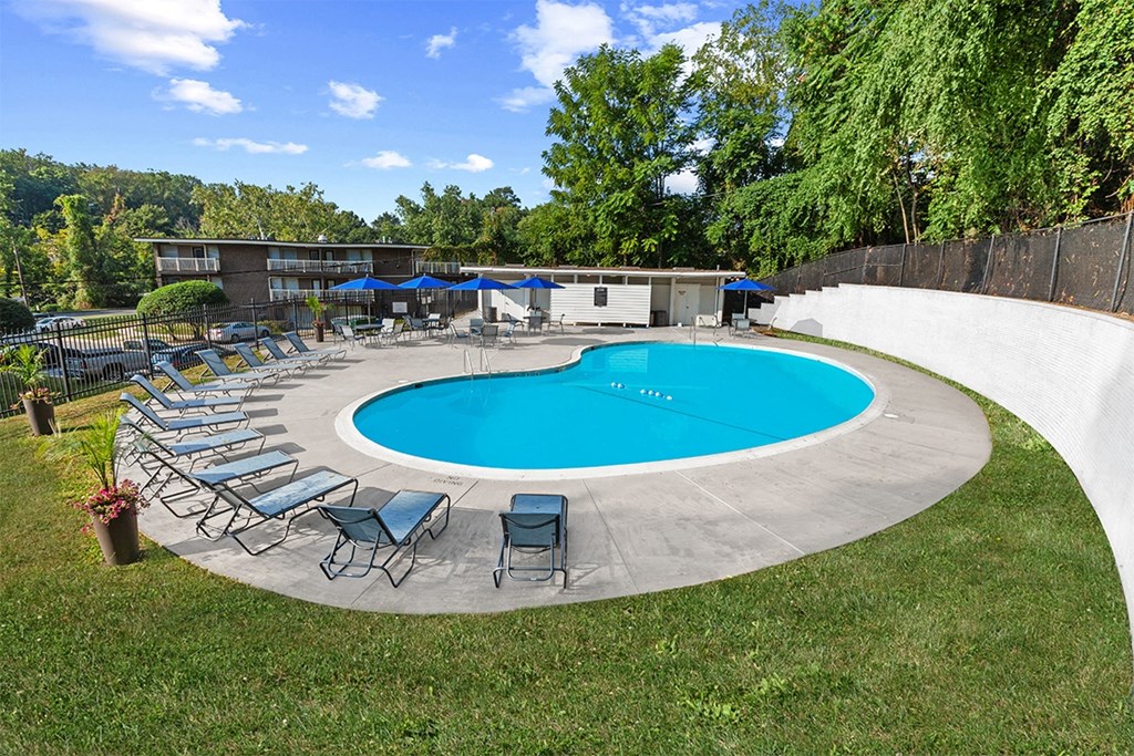 a pool with chairs and umbrellas around it at Brook View Apartments, Baltimore, 21209