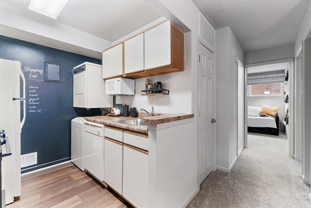 a kitchen with white cabinets and a sink and a refrigerator at Falls Village Apartments, Maryland