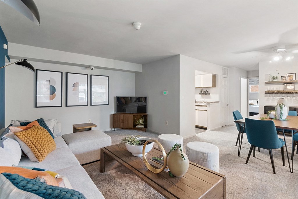 a living room and dining room with a couch and a table at Falls Village Apartments, Maryland