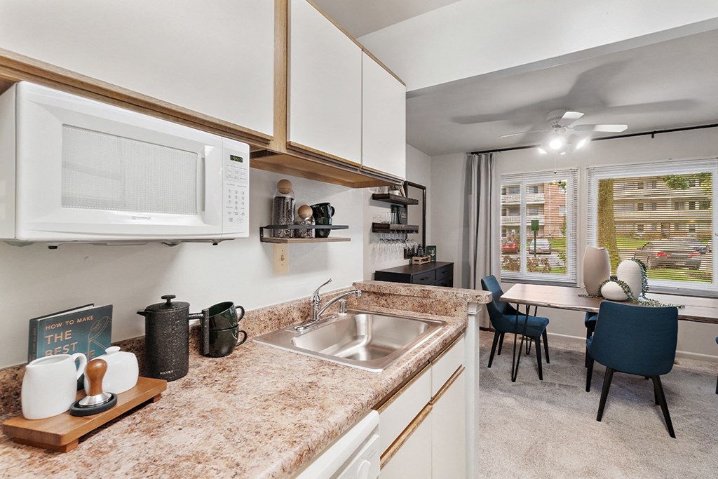 a kitchen with a sink and a microwave and a dining room at Falls Village Apartments, Maryland, 21209