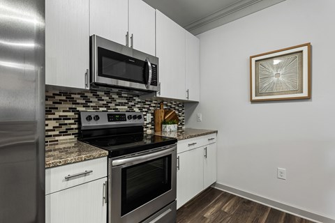 A kitchen with a stove top oven and microwave above it.