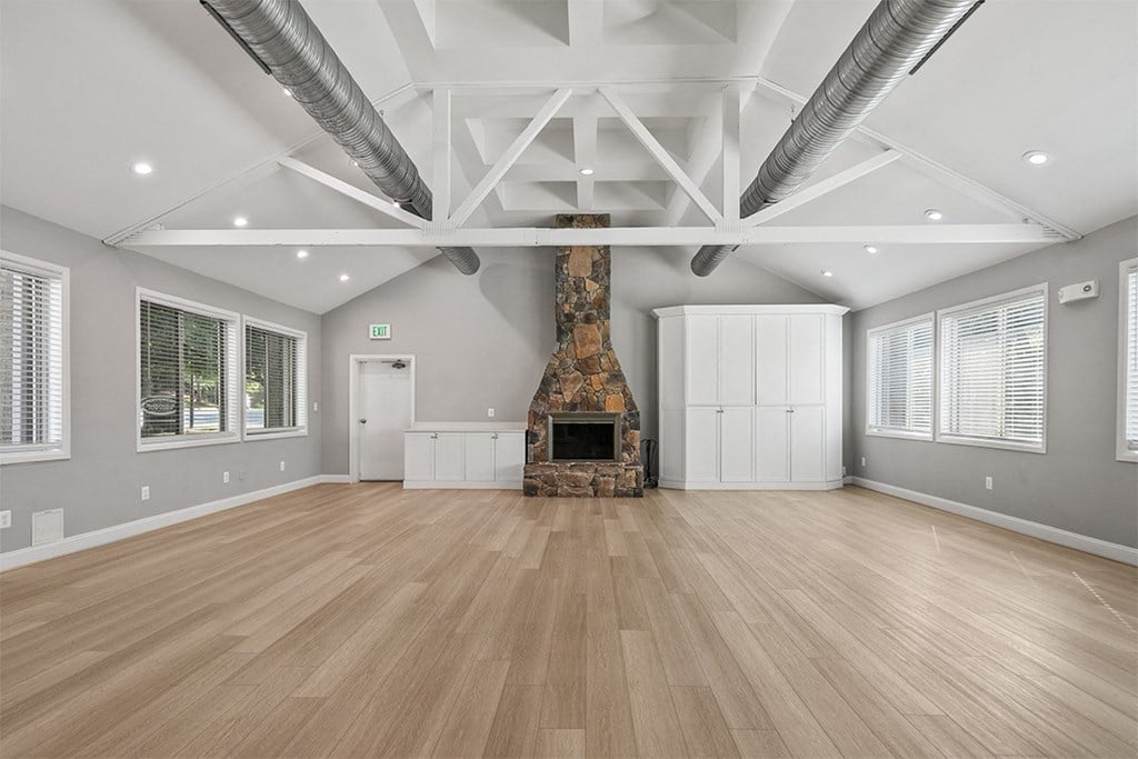 a large living room with a fireplace and wooden floors at McDonogh Township Apartments, Owings Mills