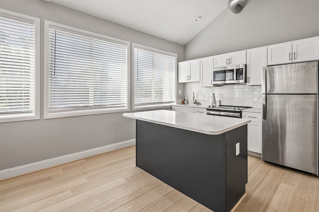 a kitchen with a large island and a stainless steel refrigerator at McDonogh Township Apartments, Owings Mills, MD, 21117
