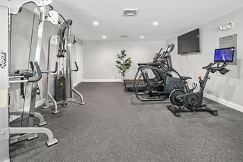 a gym with exercise equipment and a tv on the wall at McDonogh Township Apartments, Maryland