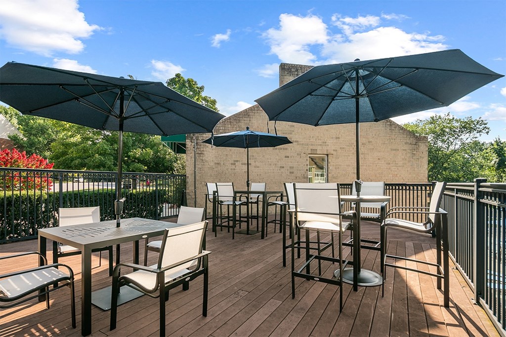 an outdoor patio with tables and chairs and umbrellas at McDonogh Township Apartments, Owings Mills, Maryland