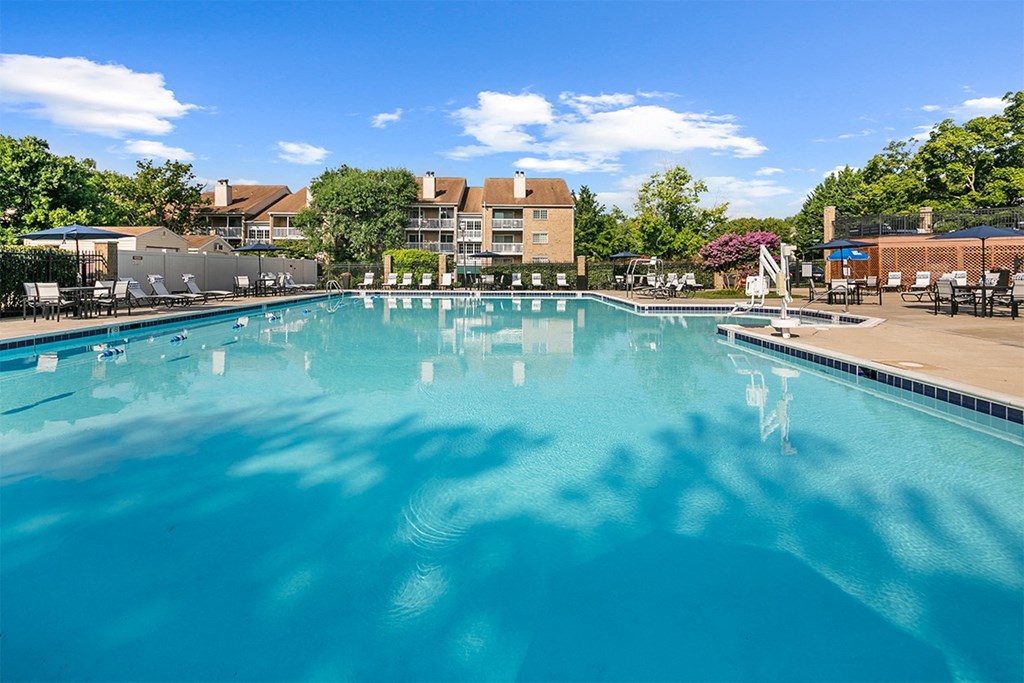 a large swimming pool with a building in the background at McDonogh Township Apartments, Owings Mills, MD