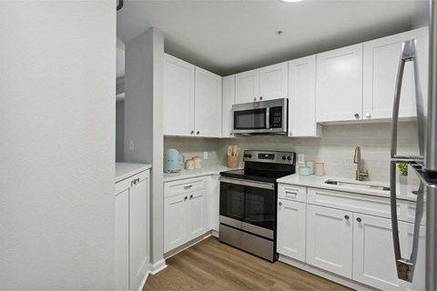 a kitchen with white cabinets and a stove and a microwave