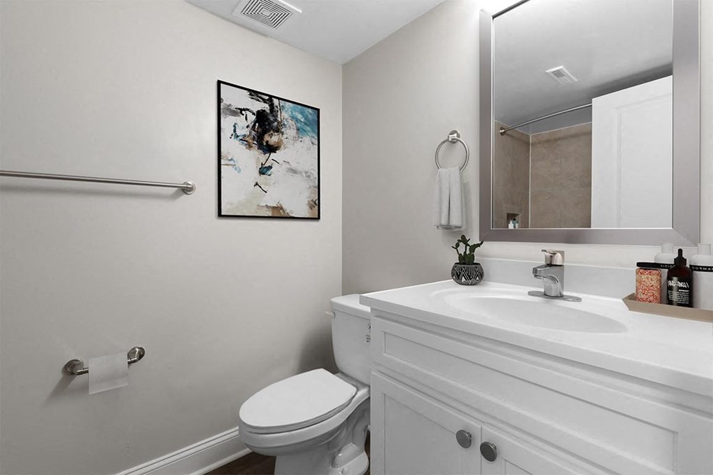 a white bathroom with a toilet and a sink at Padonia Village Apartments, Timonium, MD