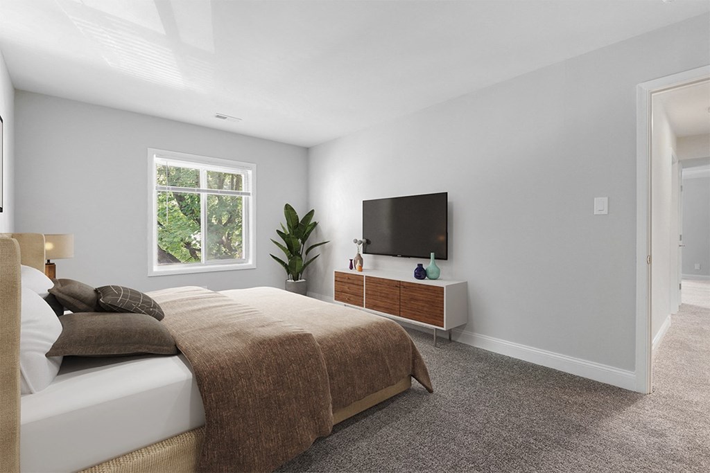 a bedroom with a large bed and a tv on the wall at Padonia Village Apartments, Timonium MD