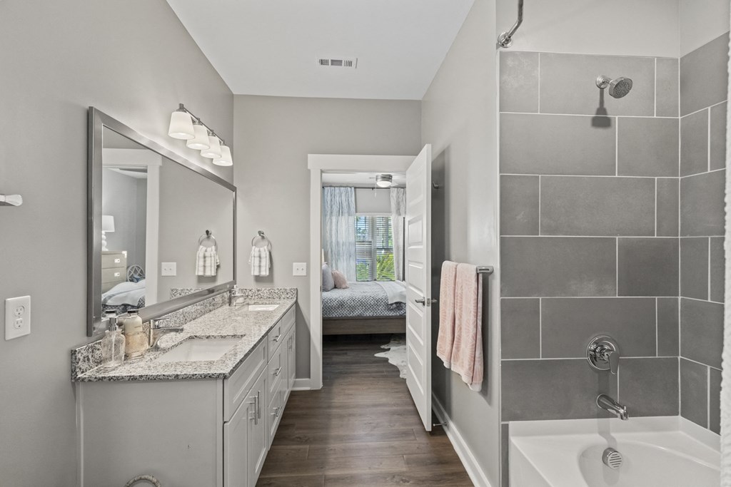 a bathroom with a shower and a sink and a mirror at Central Island Square, Daniel Island