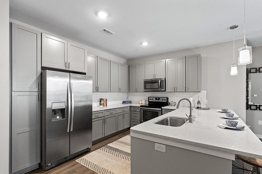 a large kitchen with stainless steel appliances and white counter tops  at Central Island Square, South Carolina