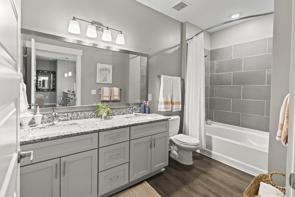 a bathroom with a large mirror and a toilet and a shower at Central Island Square, Daniel Island