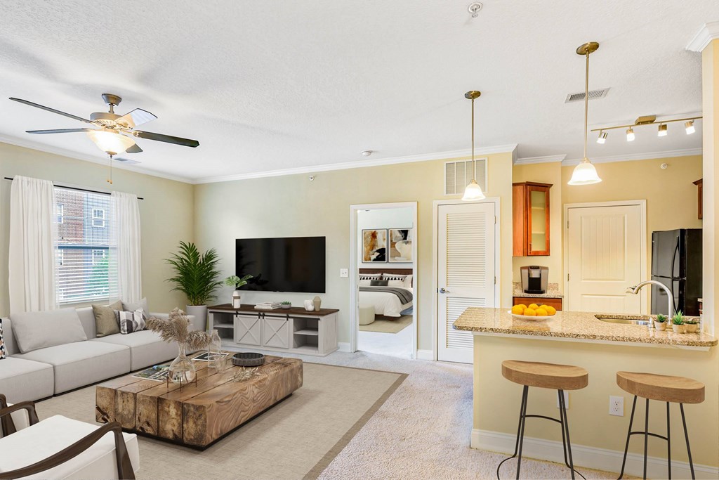 A living room with a bar area and a television at The Lofts at Reynolds Village Apartments, Asheville 92627
