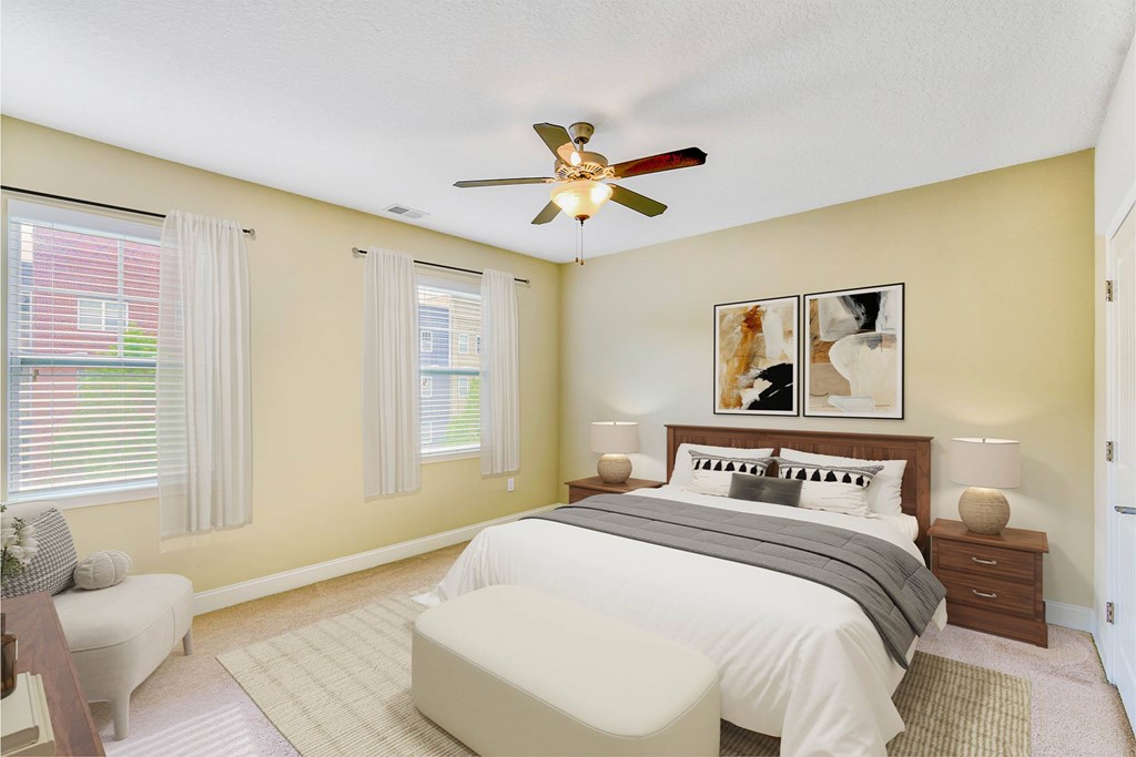 A bedroom with a bed, nightstands, and a ceiling fan at The Lofts at Reynolds Village Apartments, North Carolina, 92627