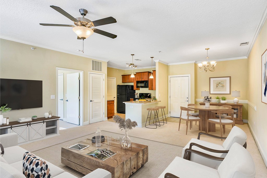 A living room with a white ceiling fan and a white couch at The Lofts at Reynolds Village Apartments, North Carolina