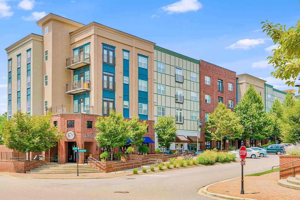 A large building with a red brick entrance and a clock on the wall at The Lofts at Reynolds Village Apartments, Asheville, North Carolina